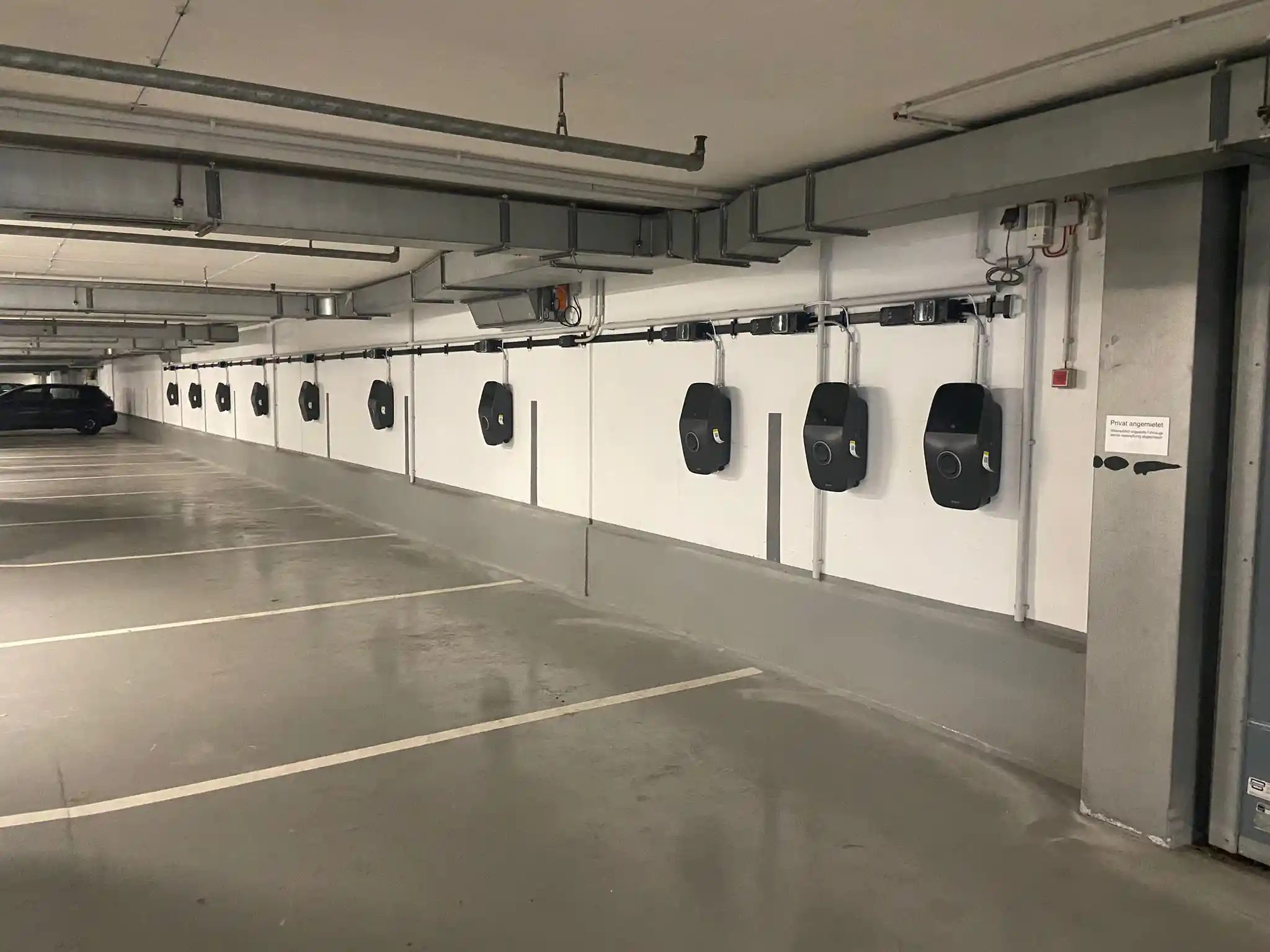 Reihe von Wallboxen entlang der Stellplätze in der Tiefgarage einer Gewerbeimmobilie in Frankfurt